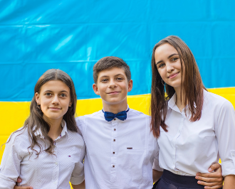 children standing in front of a ukrainian flag