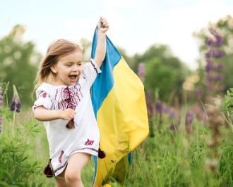 Ukrainian little girl running through the field